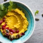 Turmeric Hummus in a blue bowl.