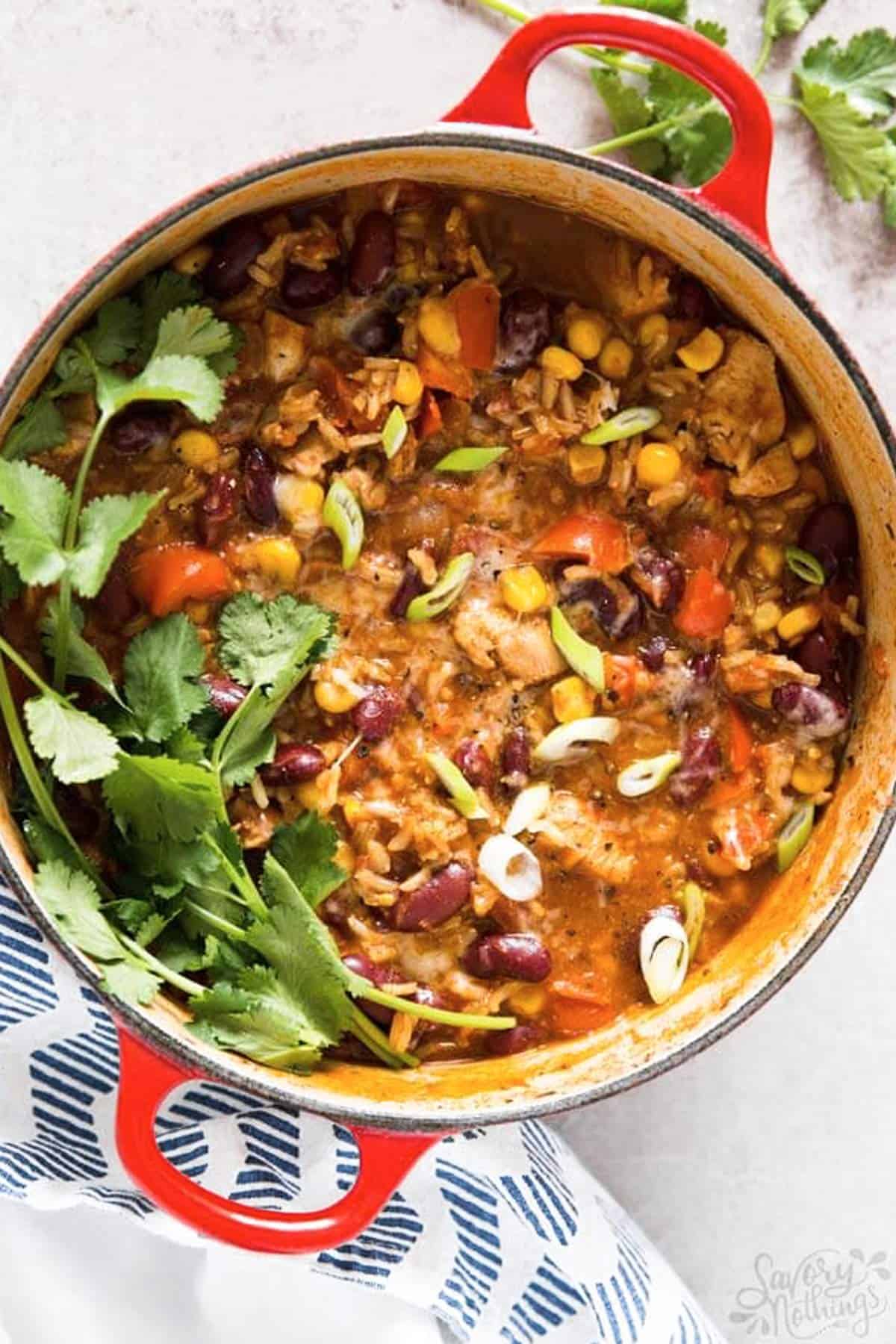 overhead view on red Dutch oven filled with burrito chicken and rice