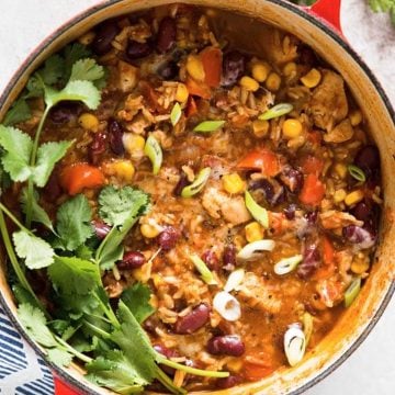 overhead view on red Dutch oven filled with burrito chicken and rice