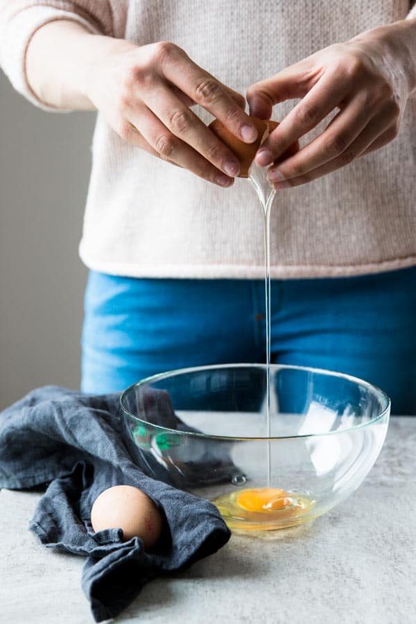 woman cracking eggs into bowl