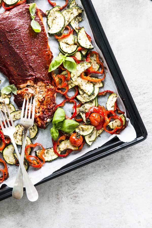top down view on two forks on a sheet pan with baked salmon and vegetables