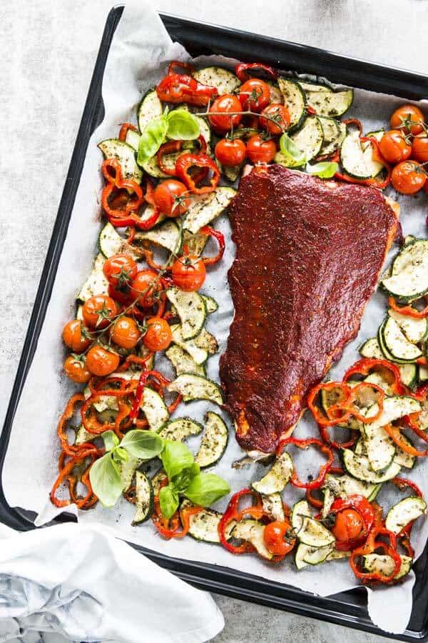 top down view on a sheet pan with tuscan baked salmon and vegetables