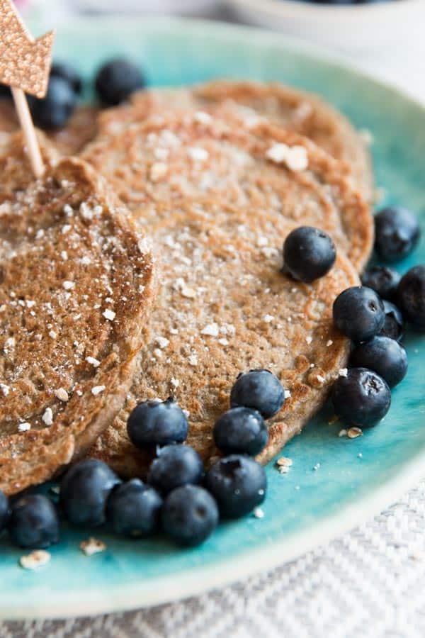 close up of healthy pancakes with blueberries on blue plate