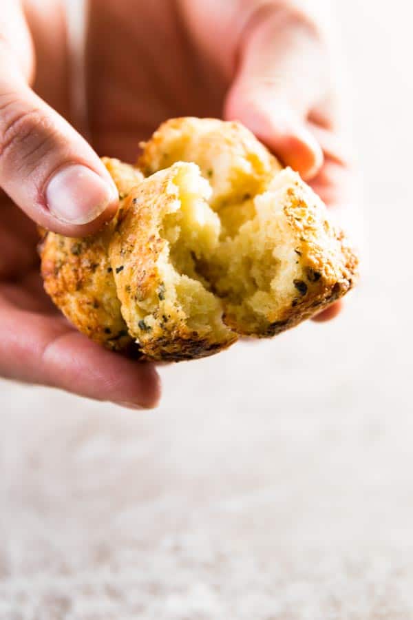 female hands breaking apart a savory monkey bread roll