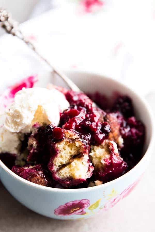 berry cobbler in colourful bowl with ice cream
