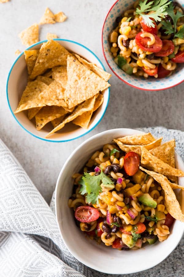 overhead view on bowls with Mexican macaroni salad and tortilla chips