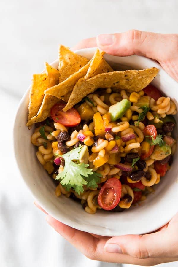 female hands holding a bowl with Mexican macaroni salad