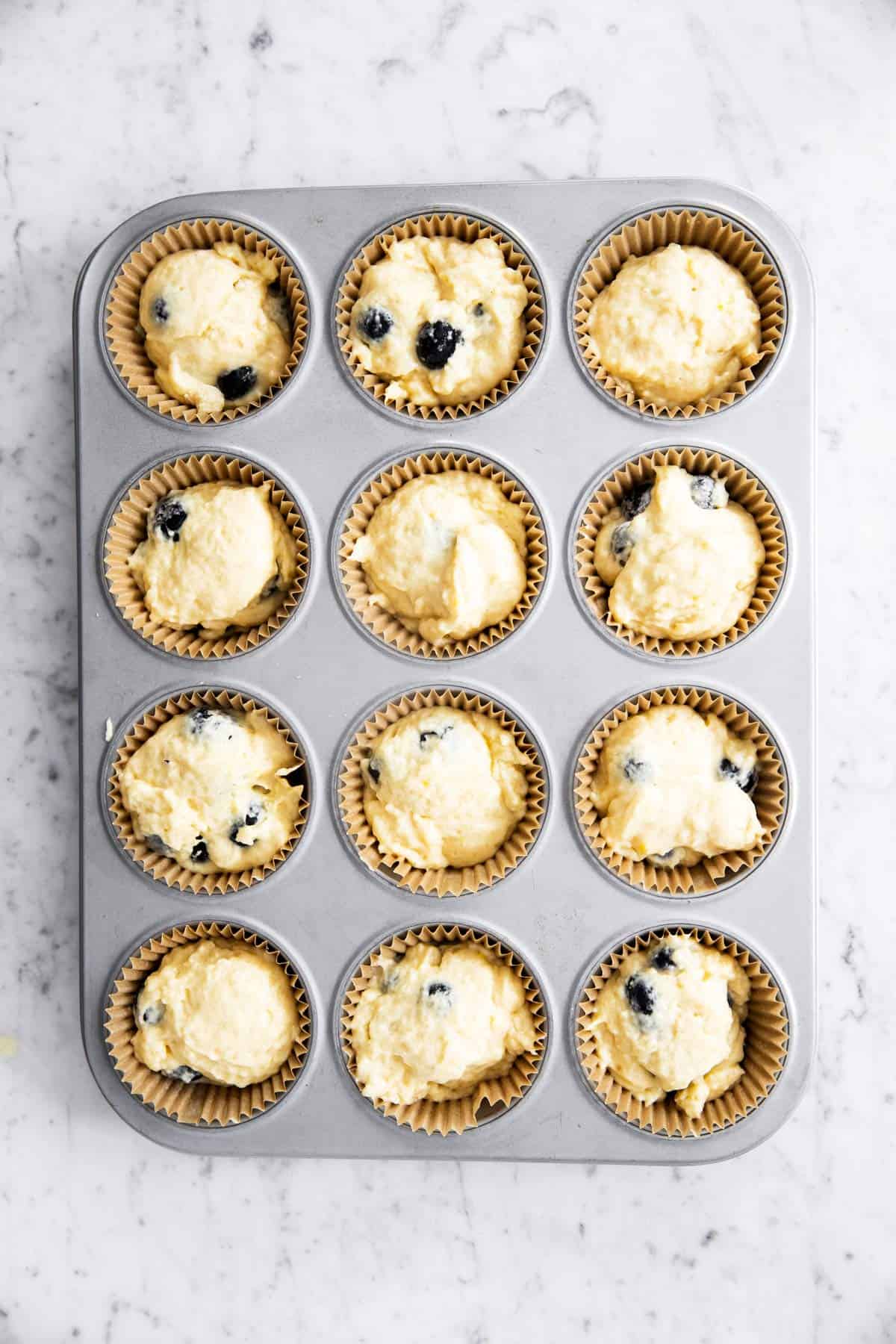 muffin cups filled with blueberry muffin batter