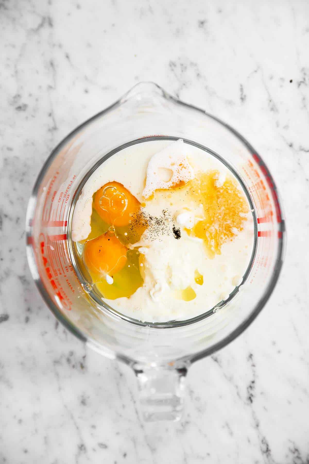 glass bowl with wet ingredients for blueberry muffin batter