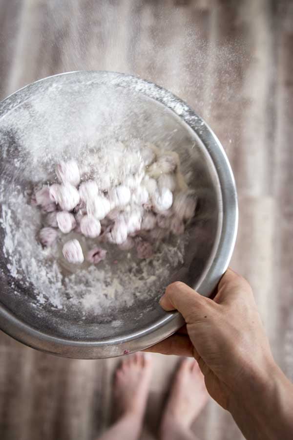 Tossing berries with flour for yogurt raspberry cake.