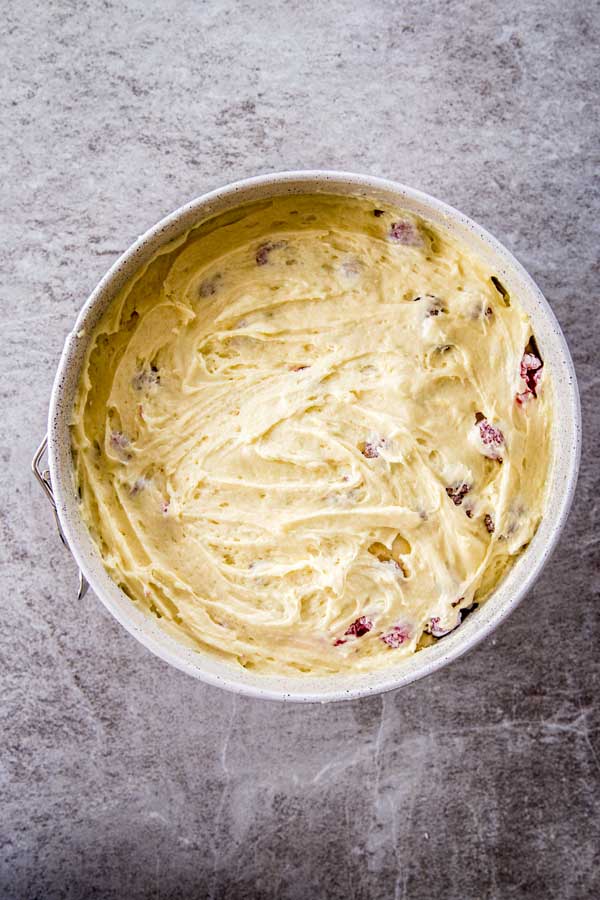 Layering batter and berries for yogurt raspberry cake.