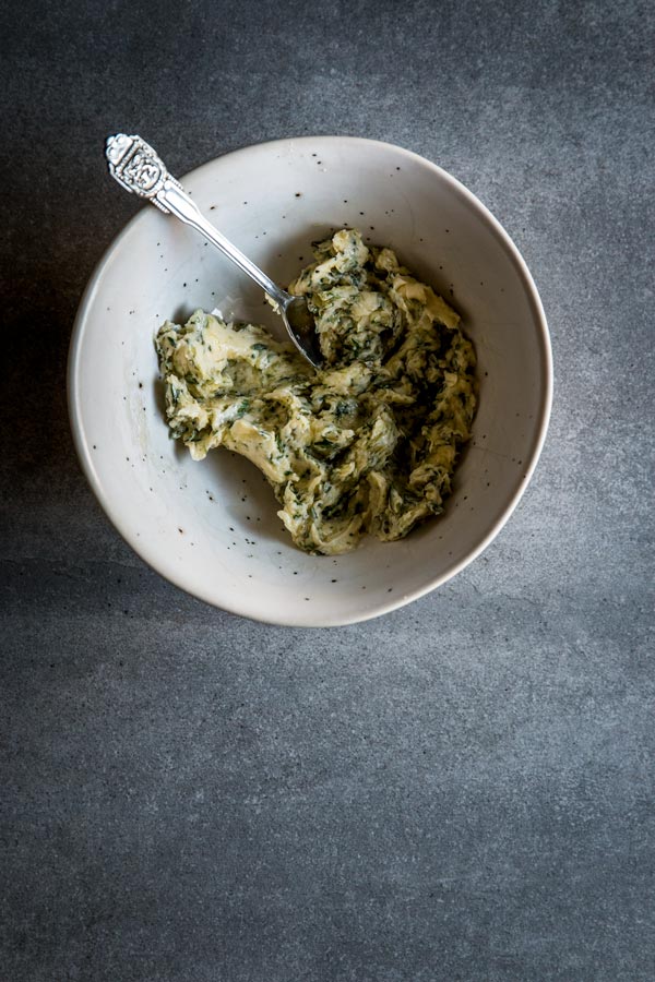 Garlic herb compound butter for baked whole fish in white bowl