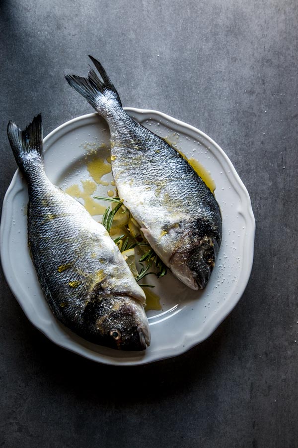 Whole fish stuffed on white plate