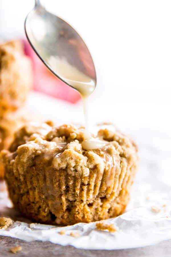 cinnamon glaze running from spoon on apple muffin