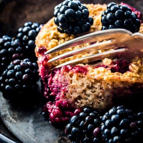 close up of fork digging into blackberry oatmeal cup