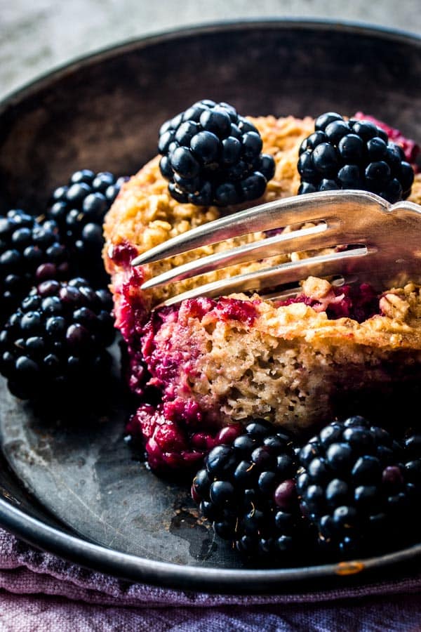 close up of fork digging into blackberry oatmeal cup