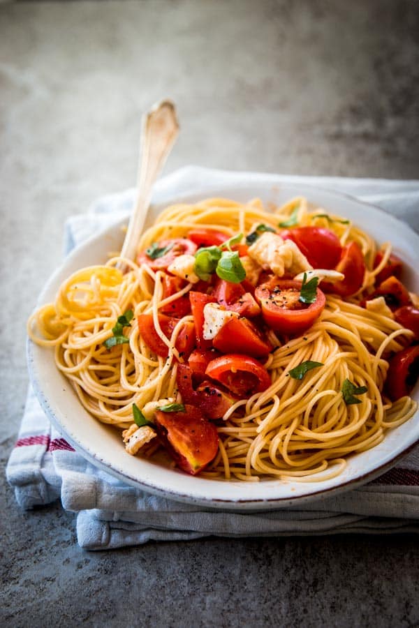 caprese pasta on a o late with a napkin