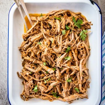 overhead view on pork carnitas in white enamel dish