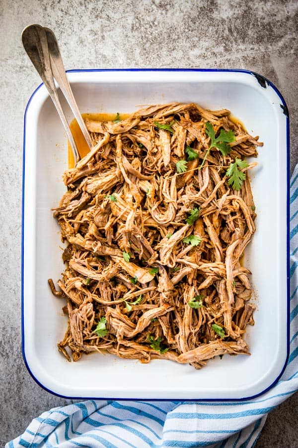 overhead view on pork carnitas in white enamel dish