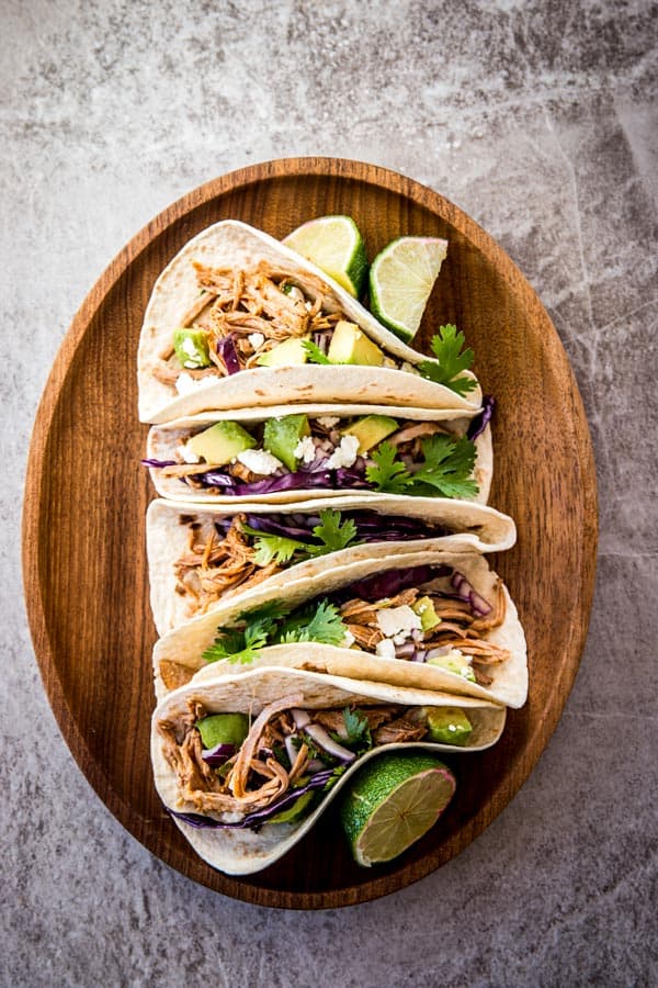 overhead view on pork tacos on wooden platter