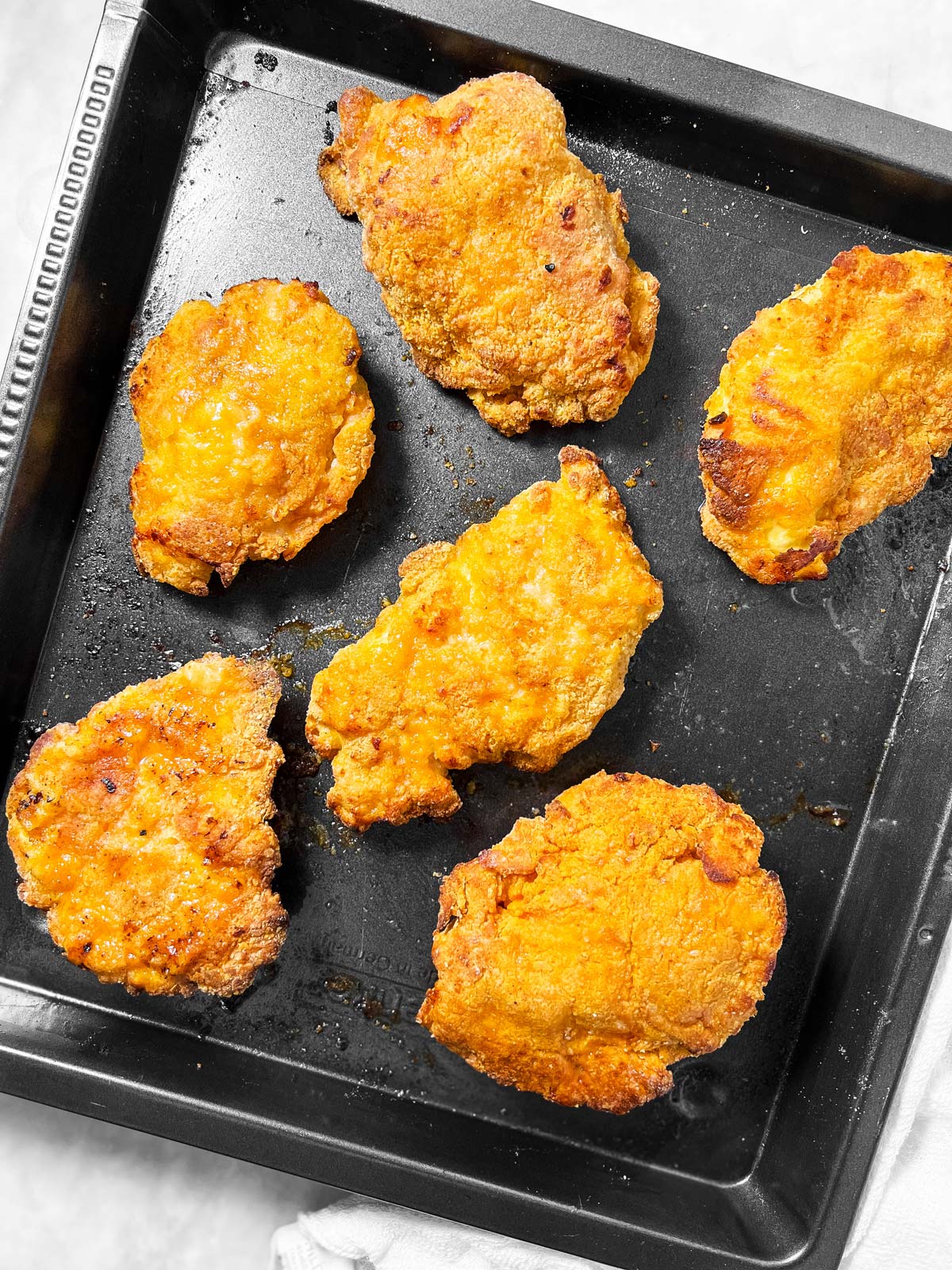 oven fried chicken on black pan