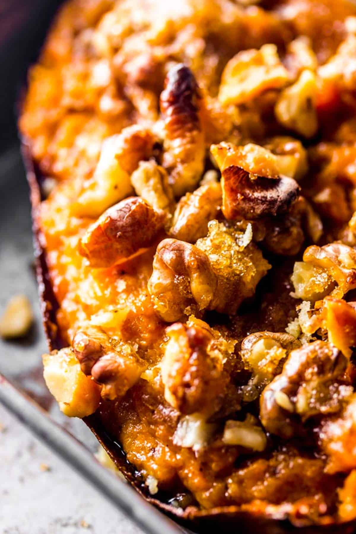 extreme close up of maple walnut topping on a twice baked sweet potato skin