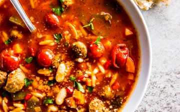 white soup plate filled with slow cooker tuscan white bean and sausage soup