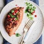 vegan stuffed sweet potato on white plate