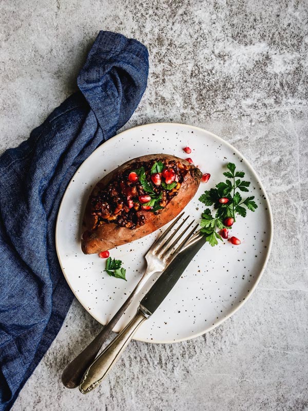 lentil stuffed sweet potato on white plate