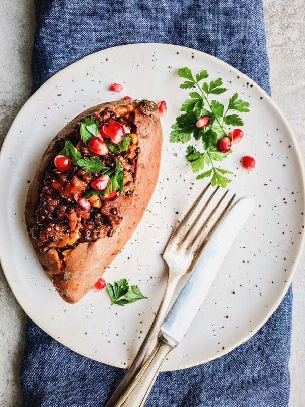 vegan stuffed sweet potato on white plate