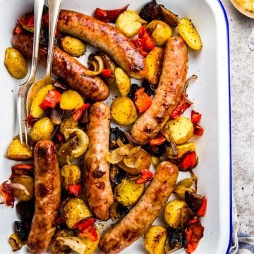 brats and peppers in white enamel pan
