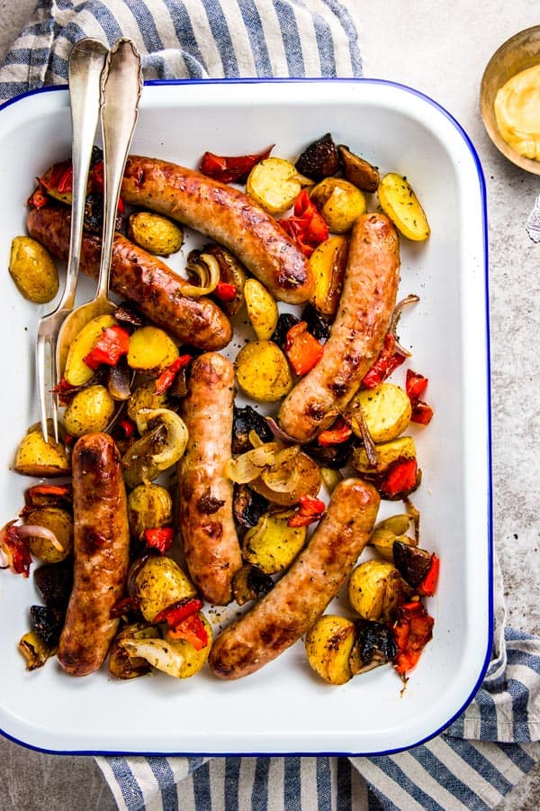 brats and peppers in white enamel pan