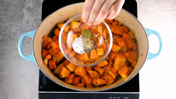 Adding spices to pumpkin soup.