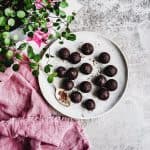 brownie bites on white plate next to pink napkin