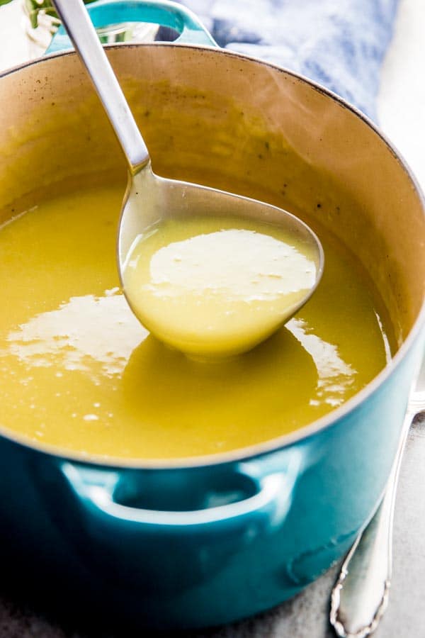 ladling potato leek soup out of blue Dutch oven