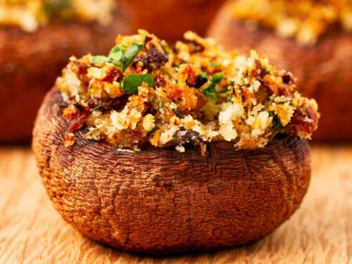 frontal view of stuffed mushroom on wooden chopping board