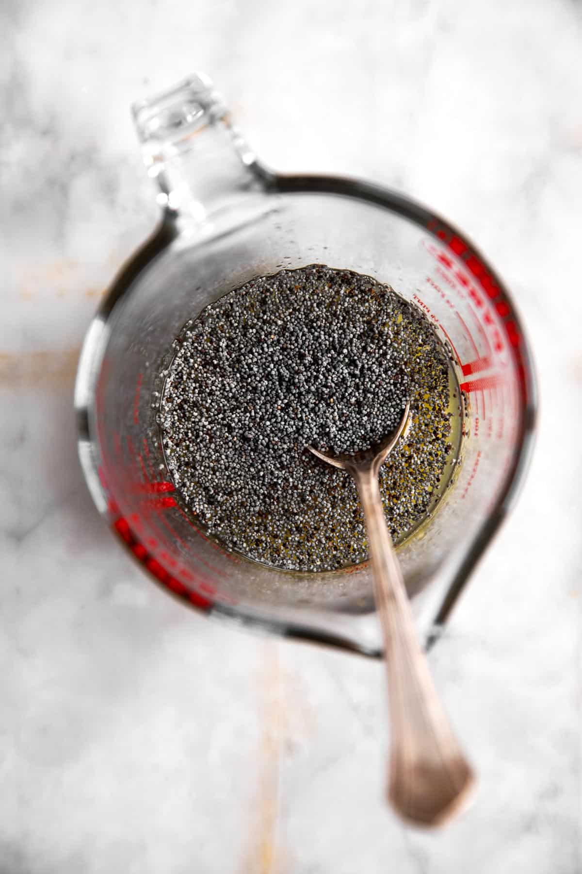 glass measuring jug with ingredients for poppy seed fruit salad dressing