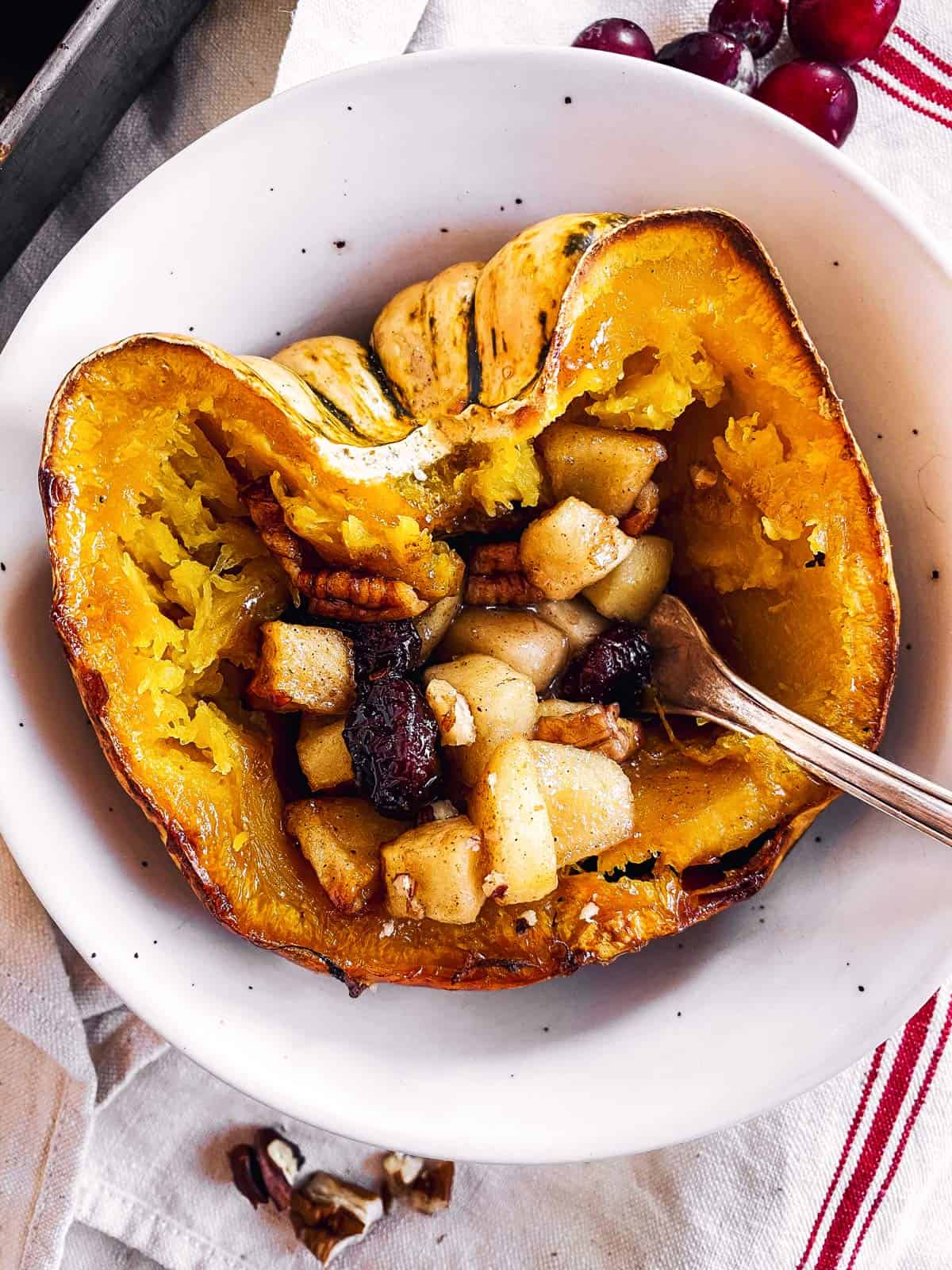 stuffed acorn squash in a white bowl with a fork