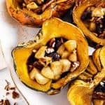 close up photo of stuffed acorn squash on white platter