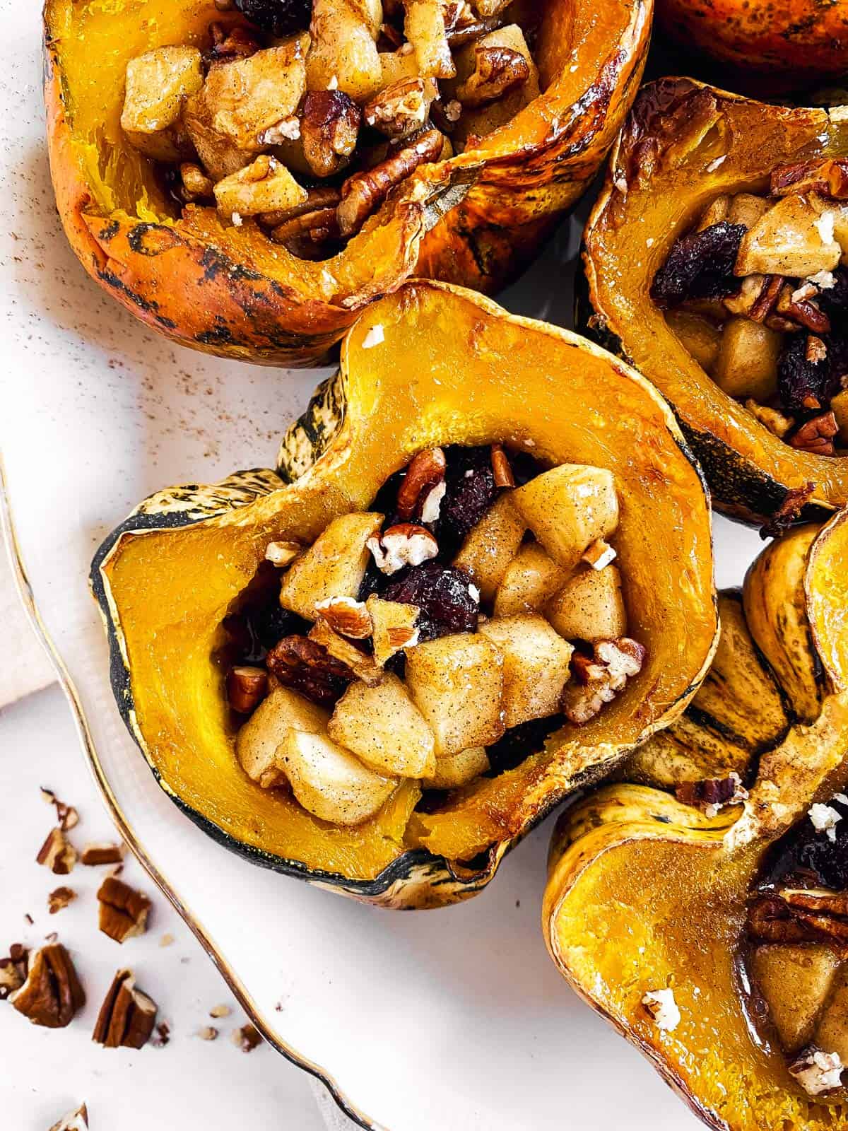close up photo of stuffed acorn squash on white platter