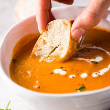 Dipping baguette in tomato soup
