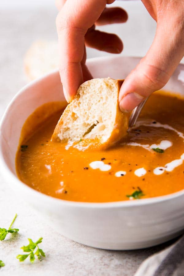 Dipping baguette in tomato soup