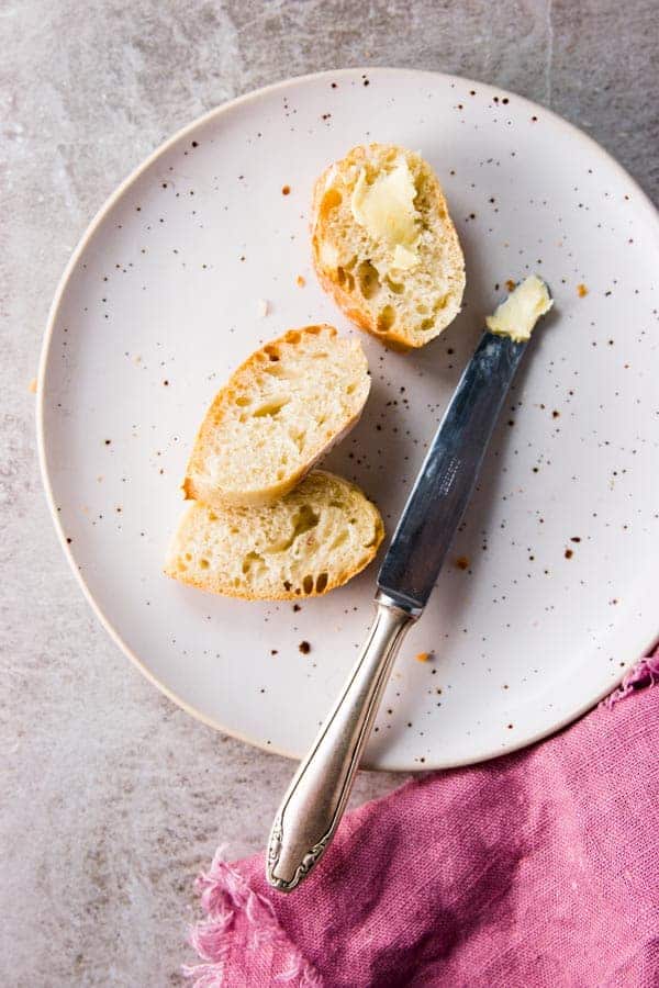 Buttered slices of no knead homemade French bread.