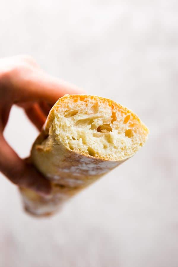 Holding a sliced homemade French bread.