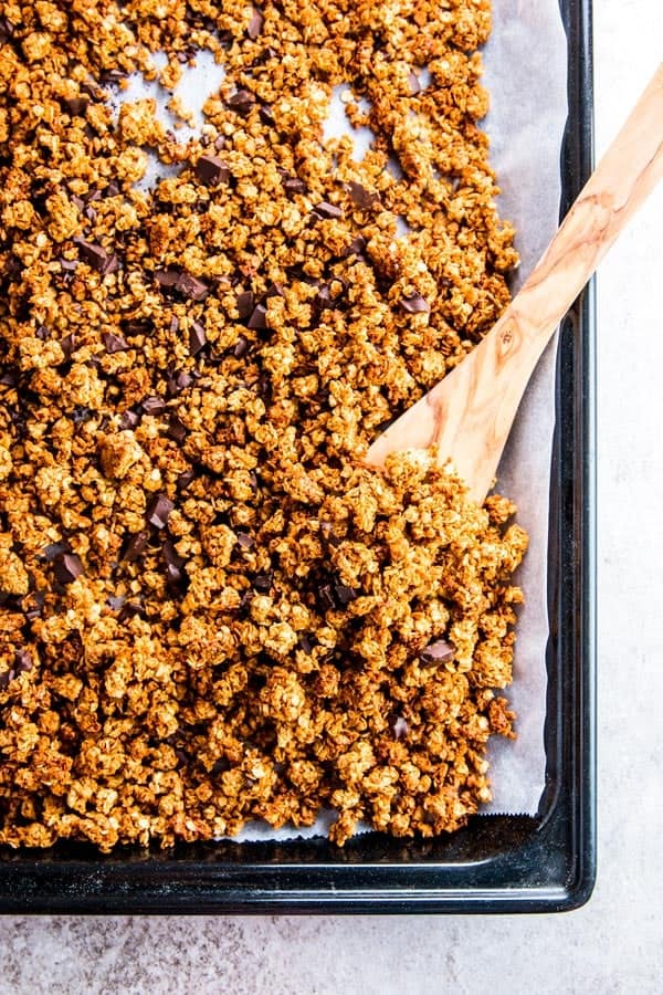 Peanut butter granola with chocolate chips on a baking sheet.