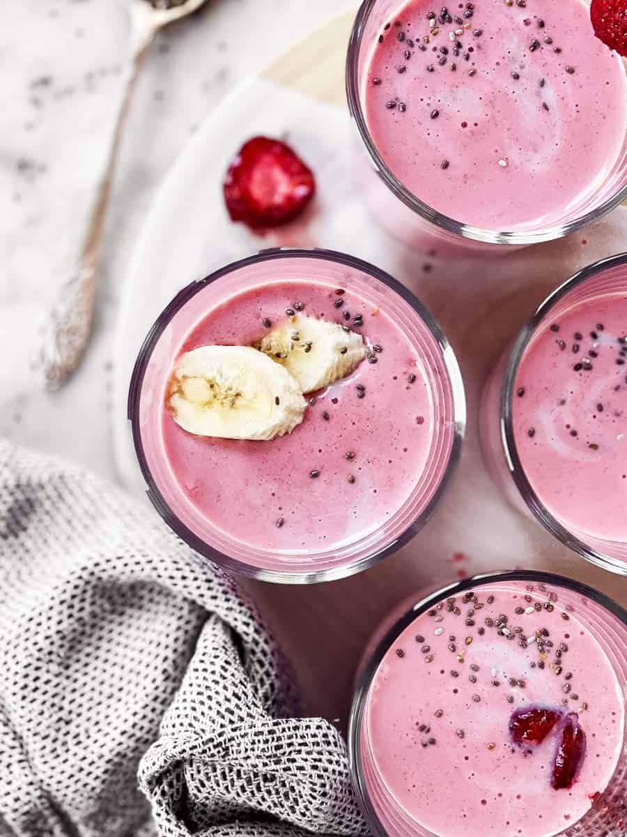 overhead view of strawberry banana smoothie in glasses