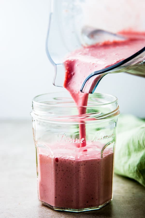 Pouring strawberry banana smoothie from the Vitamix.