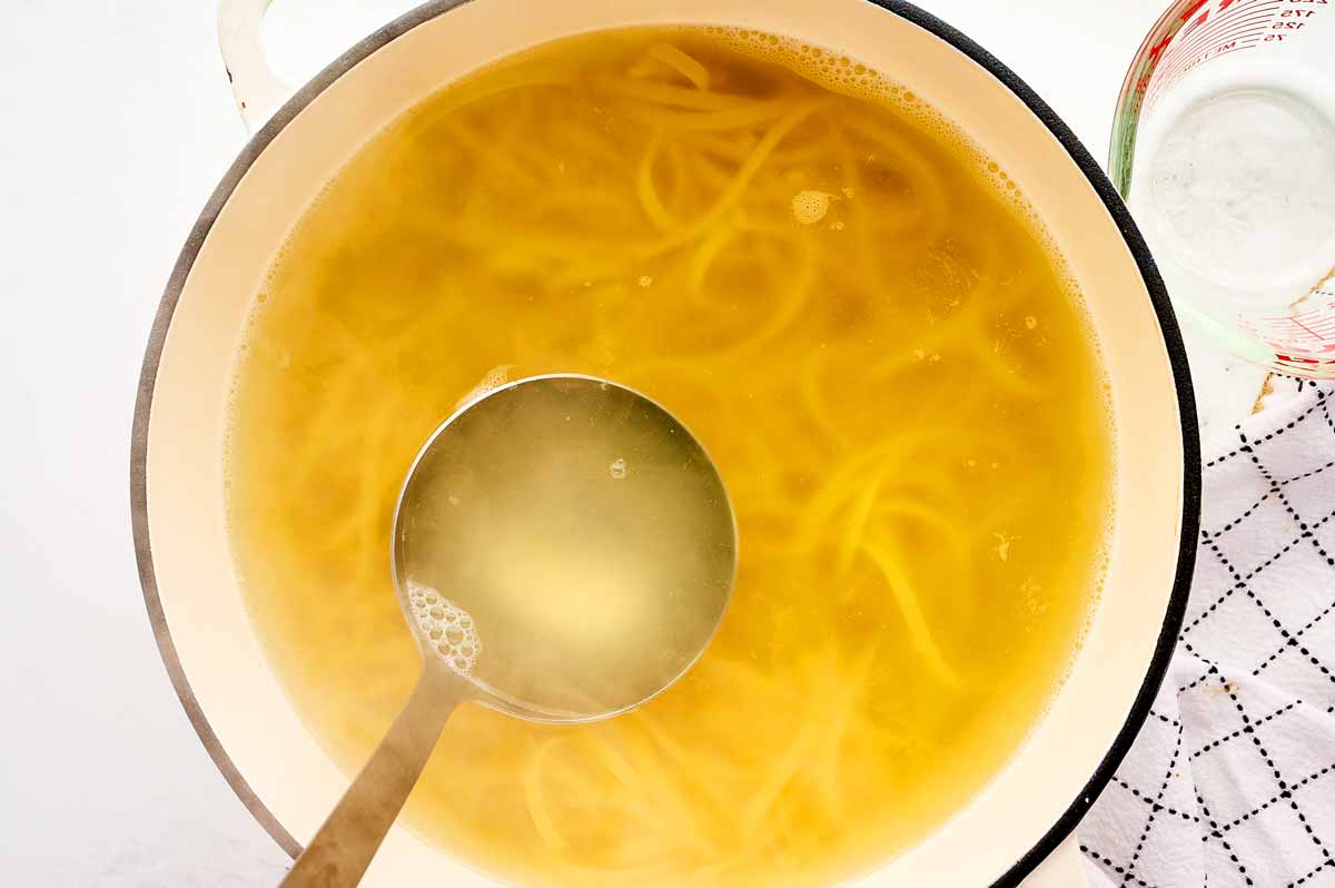 Saving pasta cooking water from a pot of linguine.
