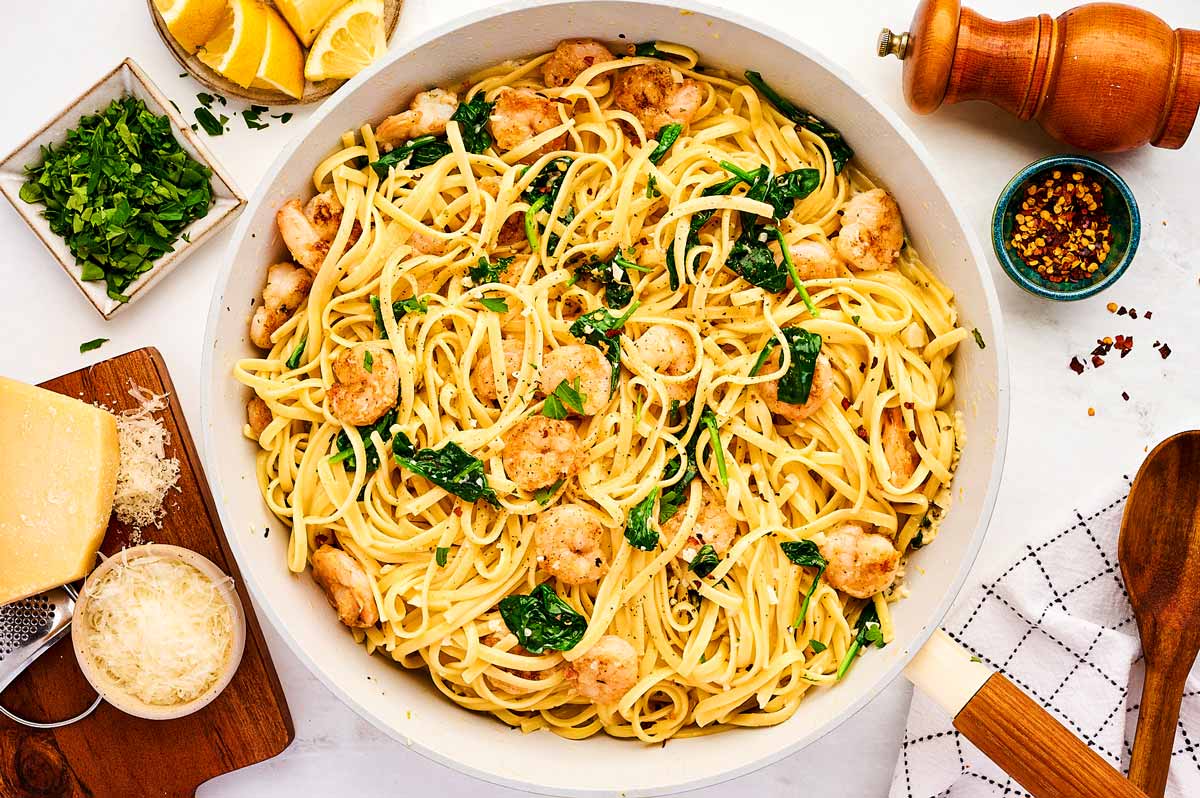 Finishing shrimp pasta in a skillet.