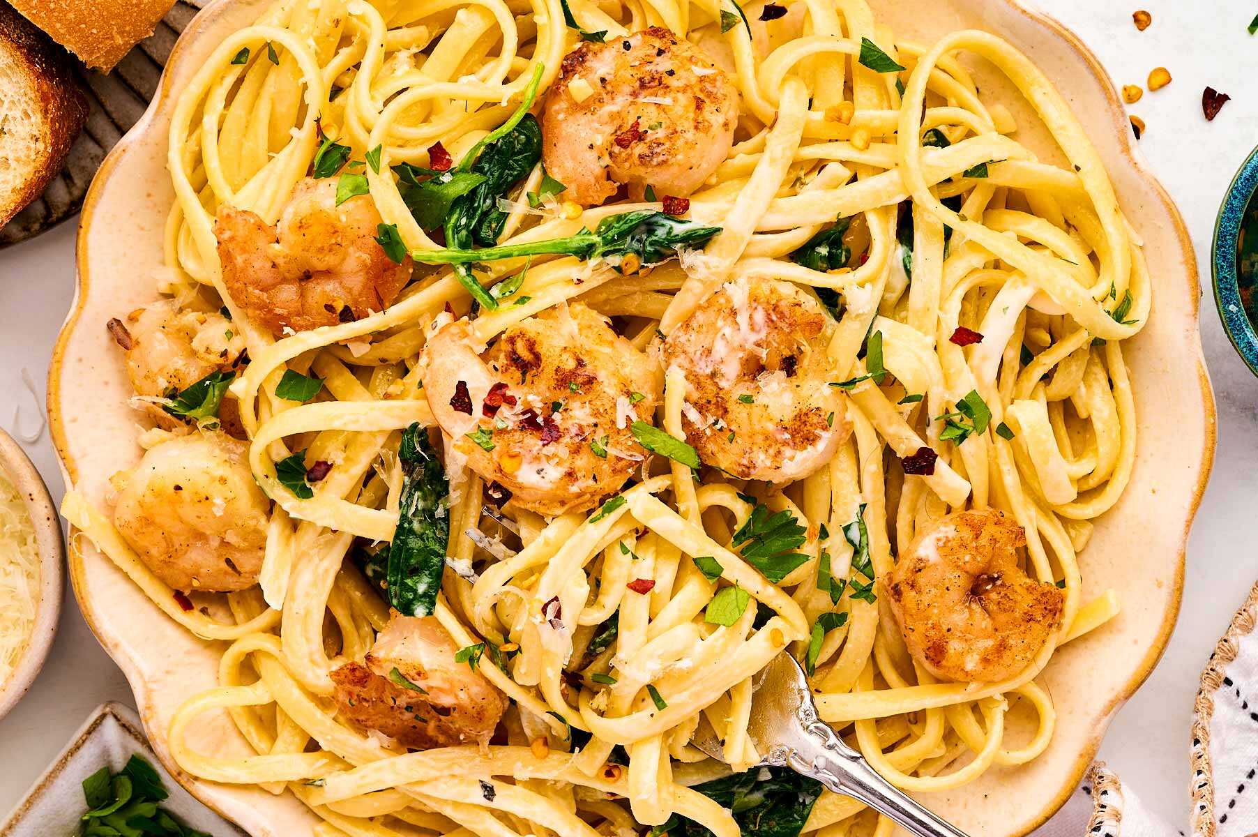 Serving a plate of shrimp pasta.